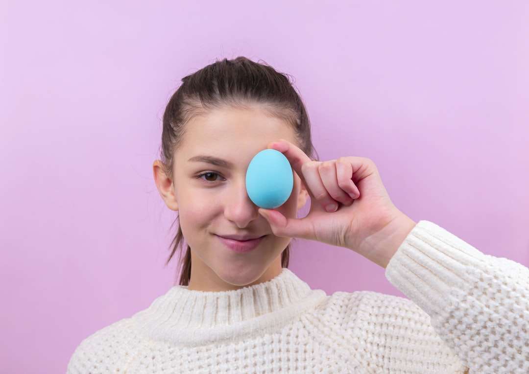 Kobieta w białym sweter gospodarstwa niebieskie jajko puzzle online