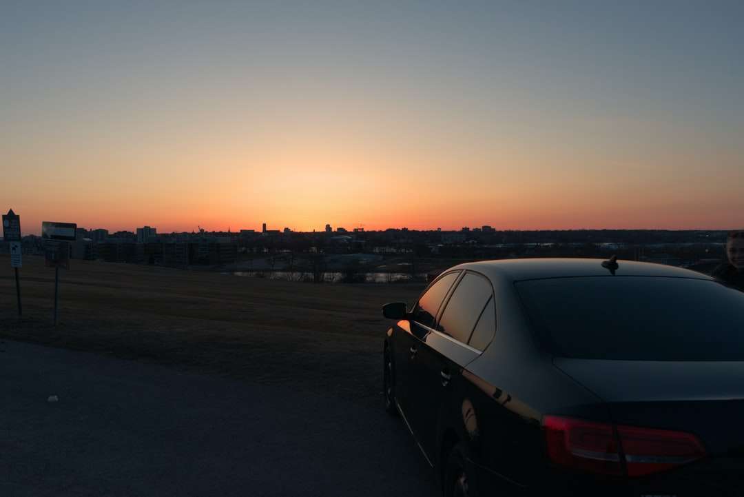 Czarny sedan na drodze podczas zachodu słońca puzzle online