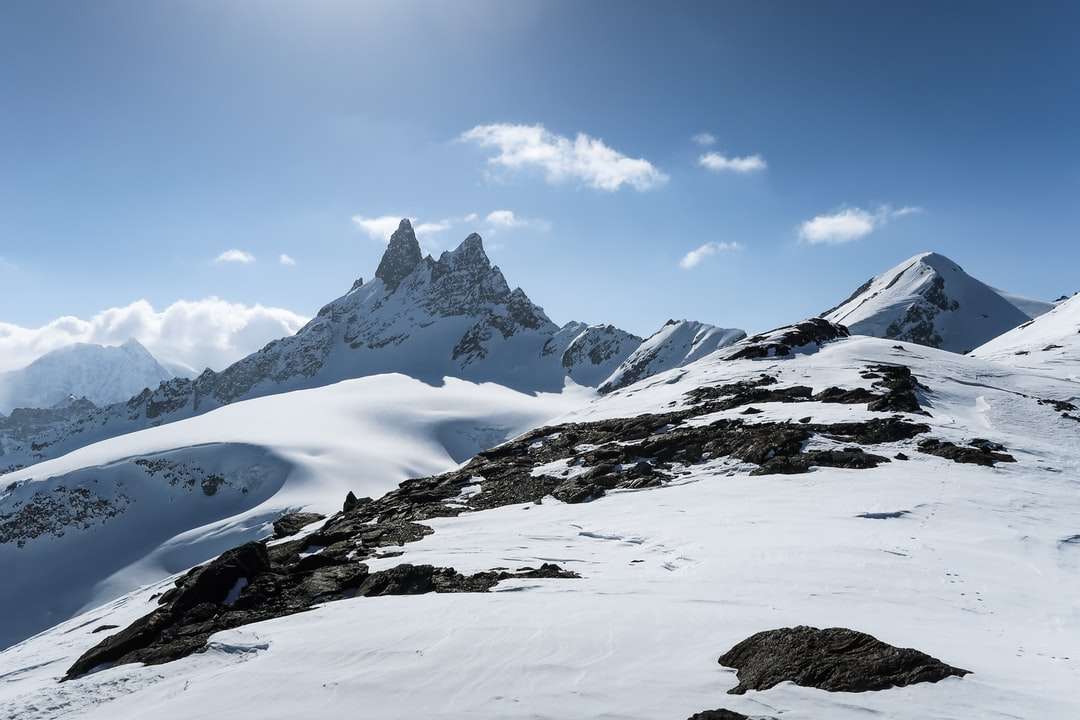 Śnieg pokryta góra pod błękitnym niebem w ciągu dnia puzzle online