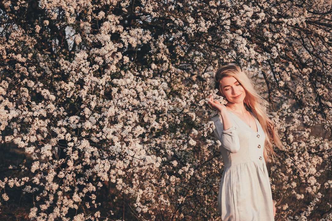 Kobieta w białej sukni pozyci na białym kwiatu polu puzzle online