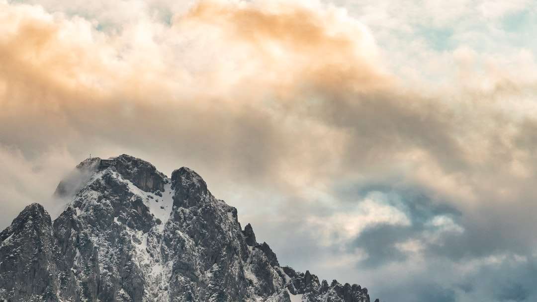 Śnieg pokryty góra pod chmurnym niebem w ciągu dnia puzzle online
