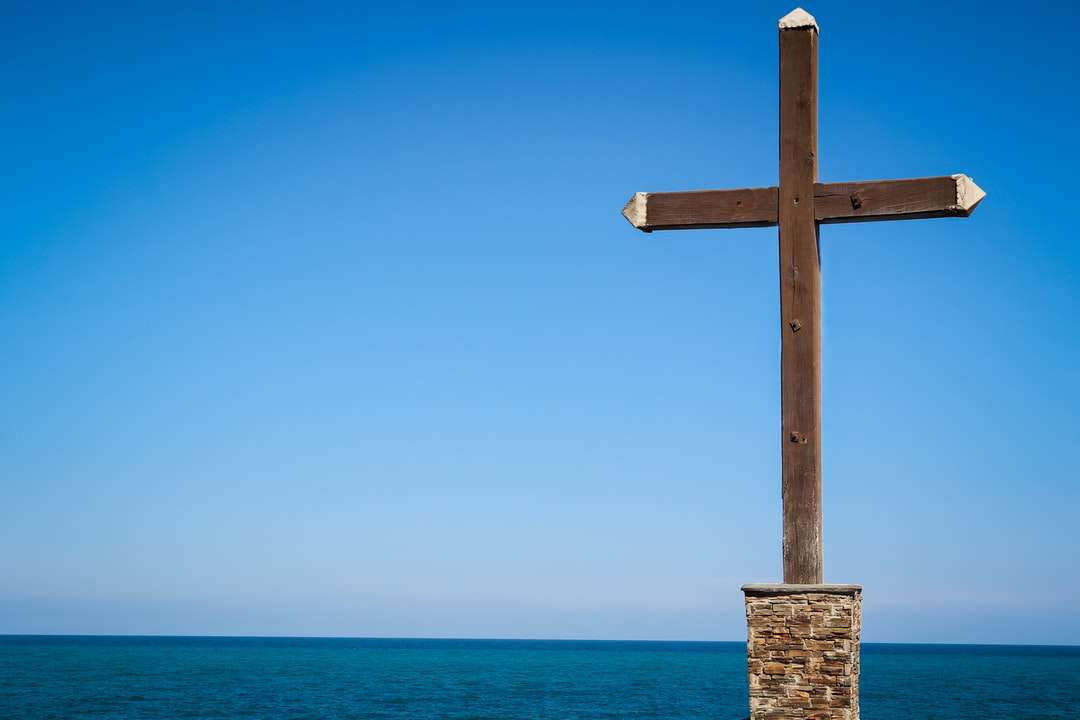 Brązowy drewniany krzyż na plaży w ciągu dnia puzzle online