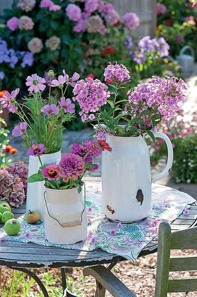 Kwiatowe ustalenia na stole ogrodowym puzzle online