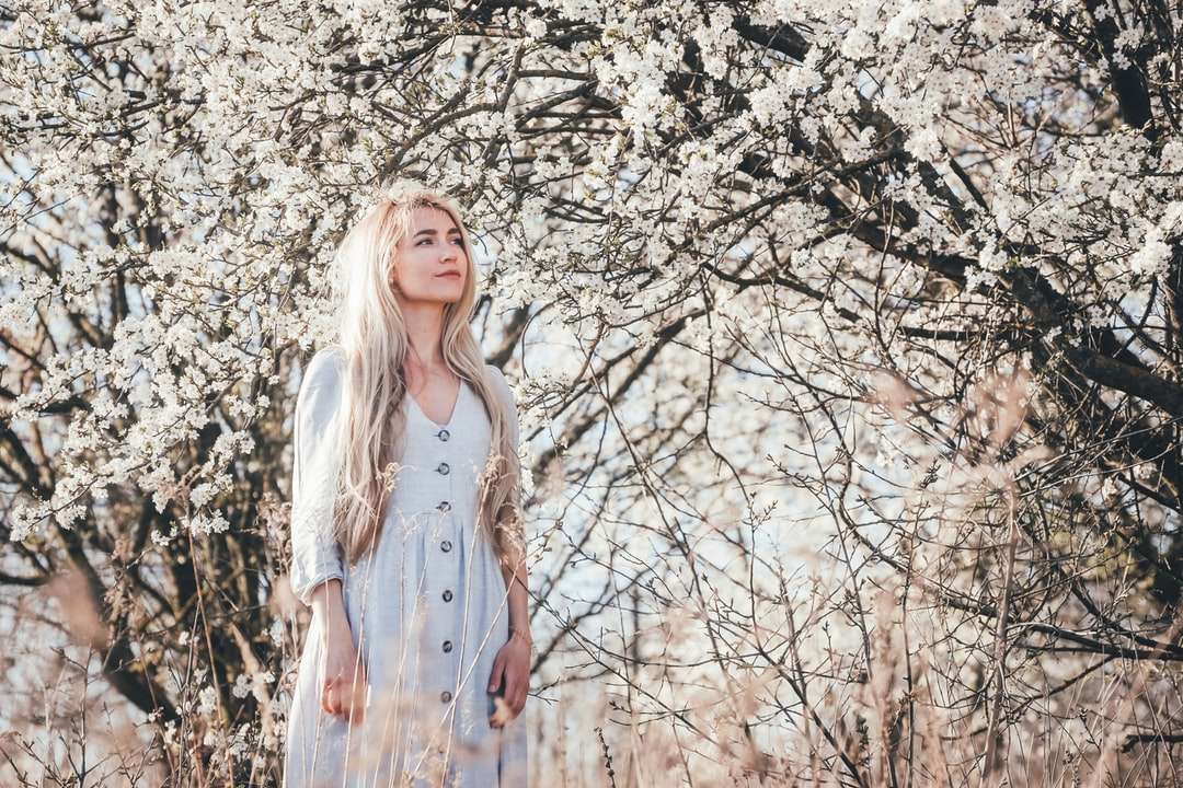 Kobieta w białej sukni stoi blisko białego liścia drzewa puzzle online