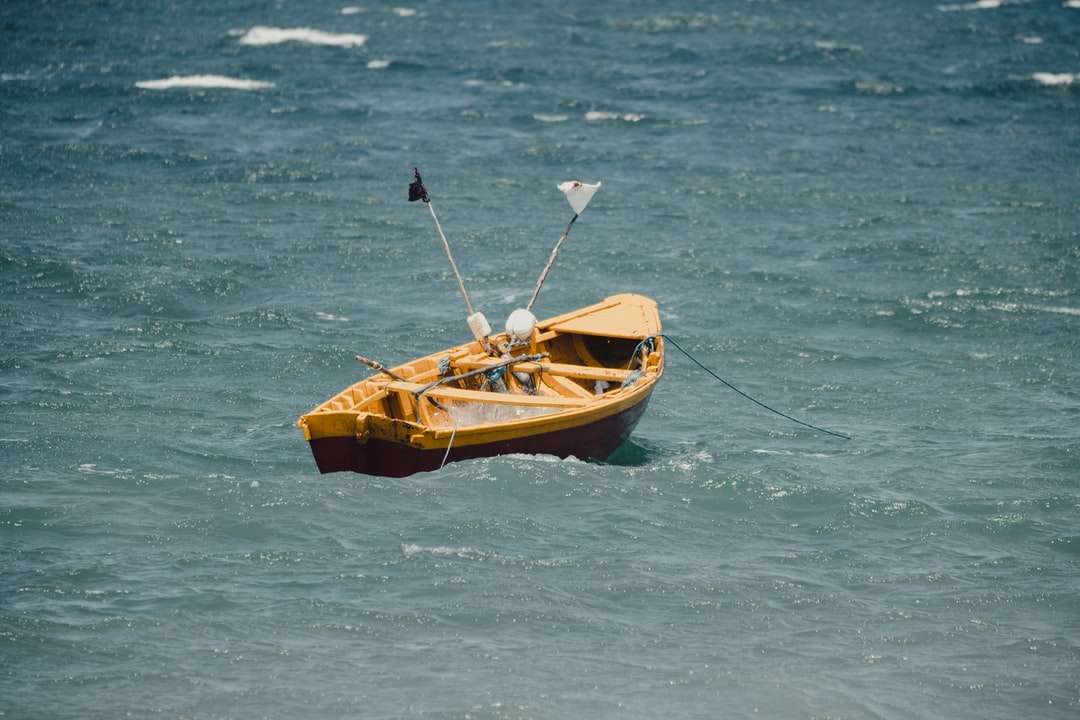 Brązowy i czarny łódź na ciele wody w ciągu dnia puzzle online