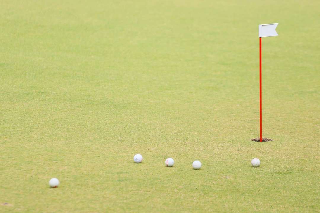 Piłka golfowa na zielonej trawie polu w ciągu dnia puzzle online
