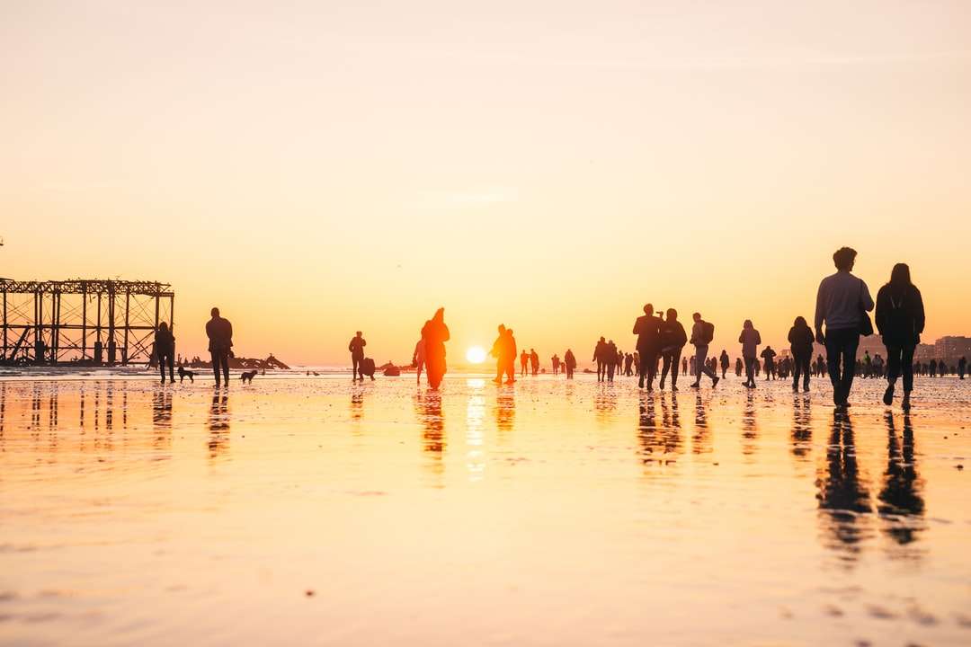 Ludzie na plaży podczas zachodu słońca puzzle online