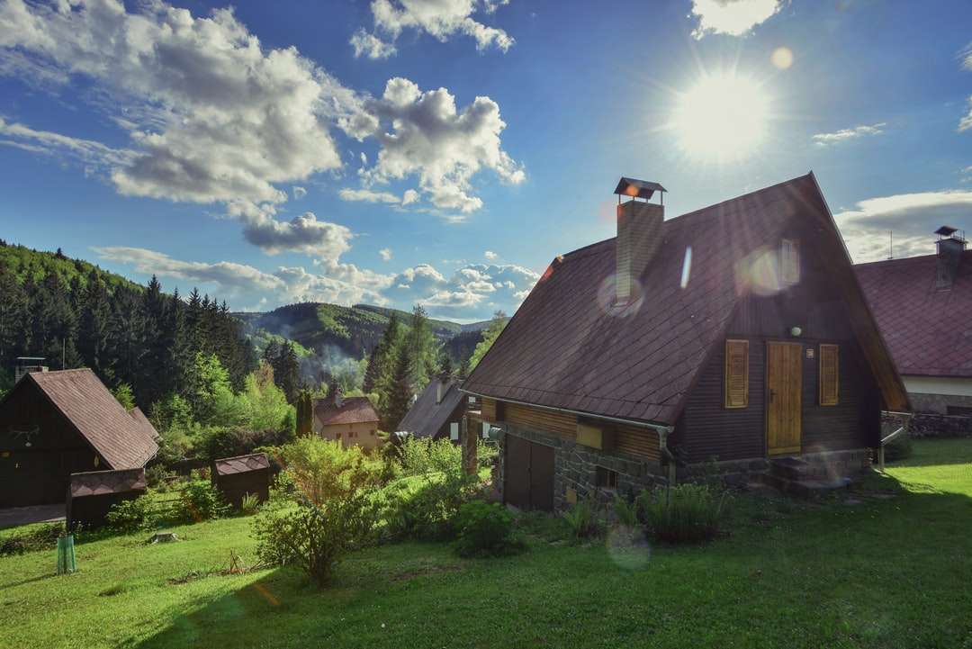 Brązowy i szary dom w pobliżu zielonych drzew pod błękitne niebo puzzle online