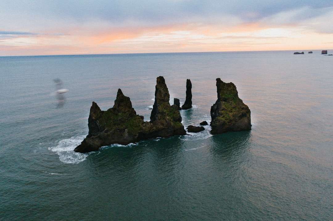 brązowa formacja skalna na błękitnym morzu w ciągu dnia puzzle online