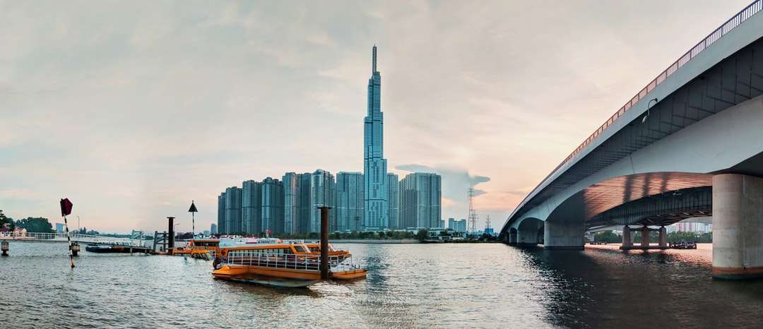 Brown łódź na wodzie w pobliżu budynków miasta w ciągu dnia puzzle online