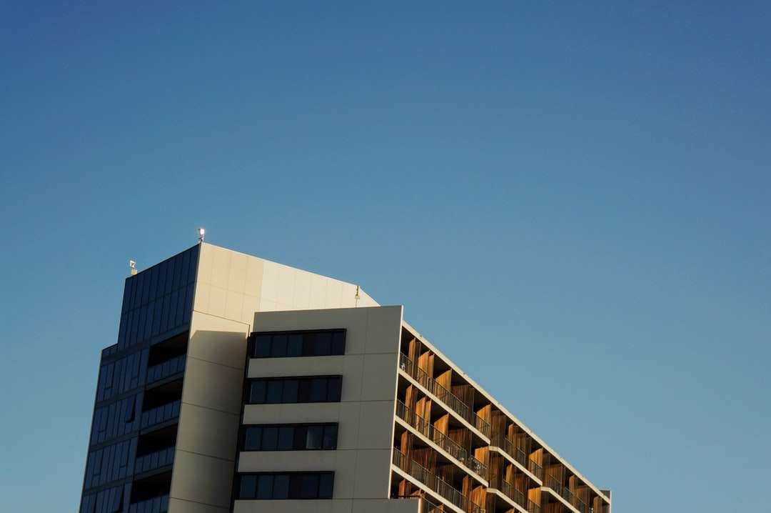 Biały i brązowy betonowy budynek pod błękitnym niebem puzzle online