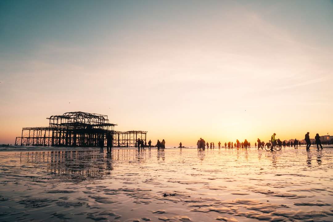 Ludzie na plaży podczas zachodu słońca puzzle online