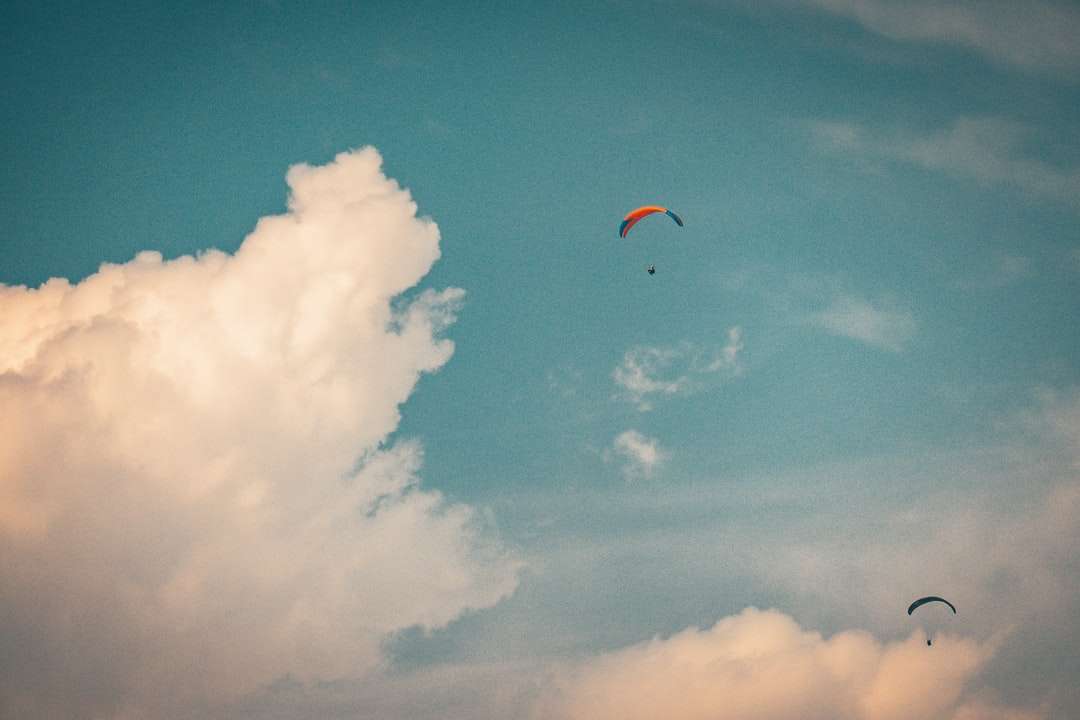 Osoba na spadochronie pod błękitnym niebem w ciągu dnia puzzle online