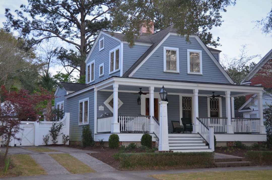 Biały i niebieski drewniany dom w pobliżu zielonych drzew w ciągu dnia puzzle online
