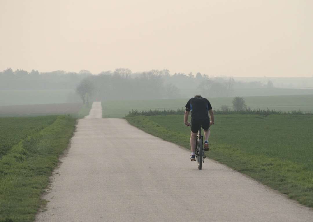 Człowiek w czarnej koszuli jazda na rowerze na szarej betonowej drodze puzzle online