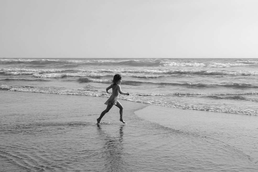 Kobieta w czarnym bikini spaceru na plaży w ciągu dnia puzzle online