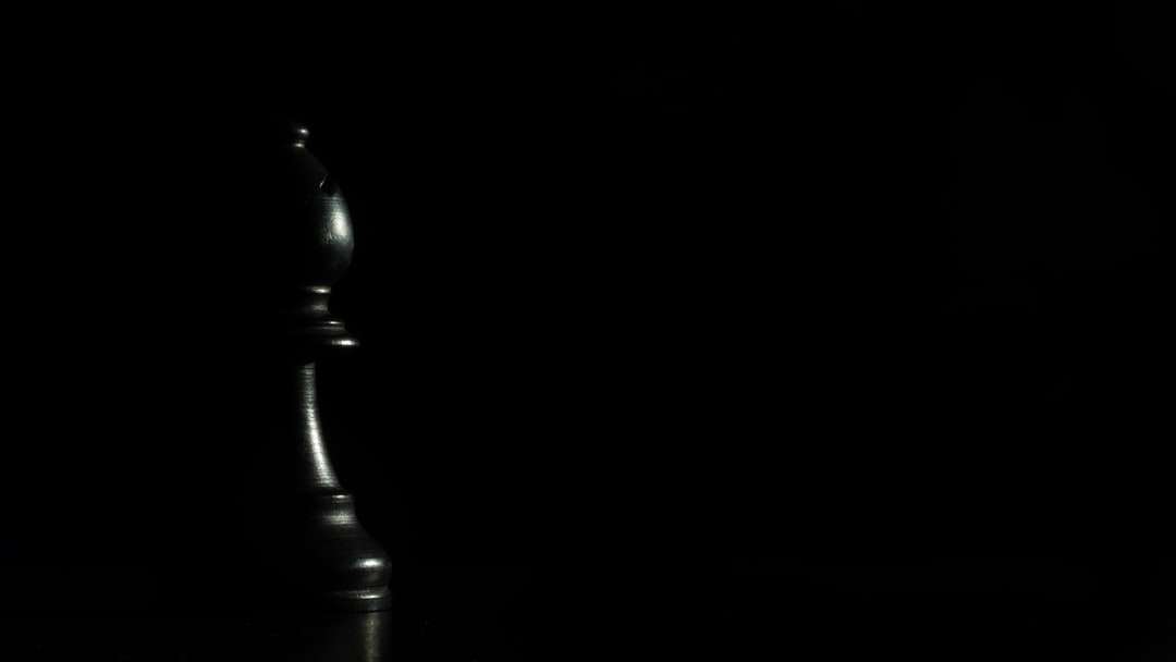 Czarny drewniany szachowy kawałek na czarnej powierzchni puzzle online