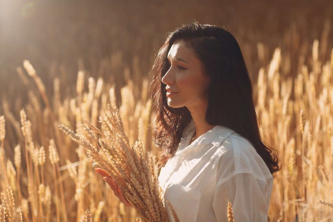 Kobieta w białej koszula stoi na brown trawy polu puzzle online