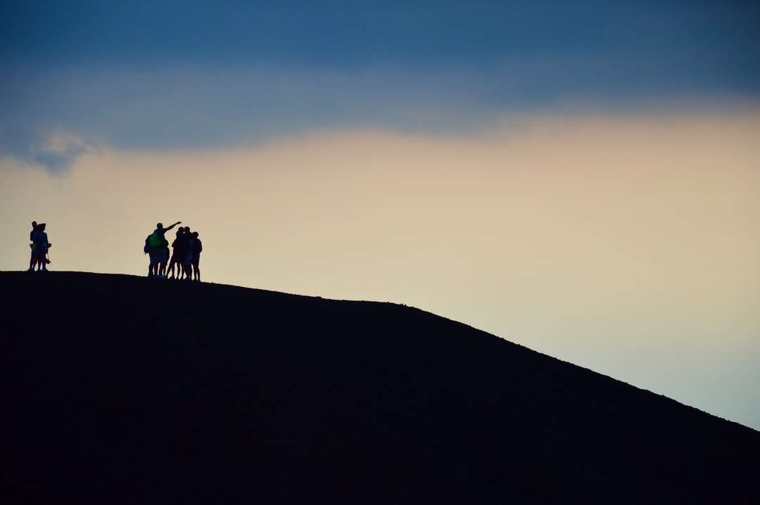 Sylwetka 2 osób stojących na szczycie wzgórza podczas zachodu słońca puzzle online