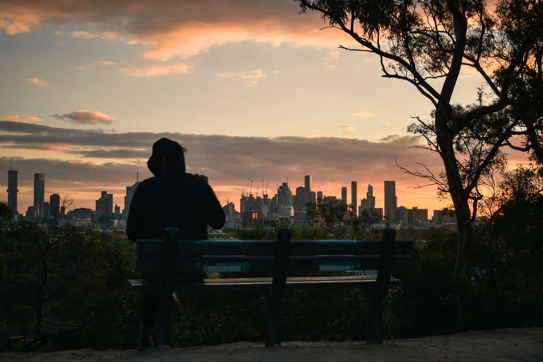 Mężczyzna siedzi na ławce podczas zachodu słońca puzzle online