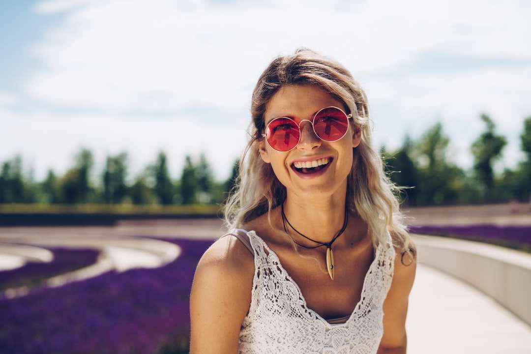 Mujer en blanco Floral Tank Top con gafas de sol rompecabezas