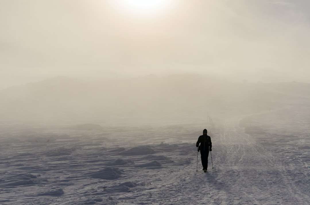 Człowiek w czarnej kurtce stojącej na śniegu pokryte ziemią puzzle online