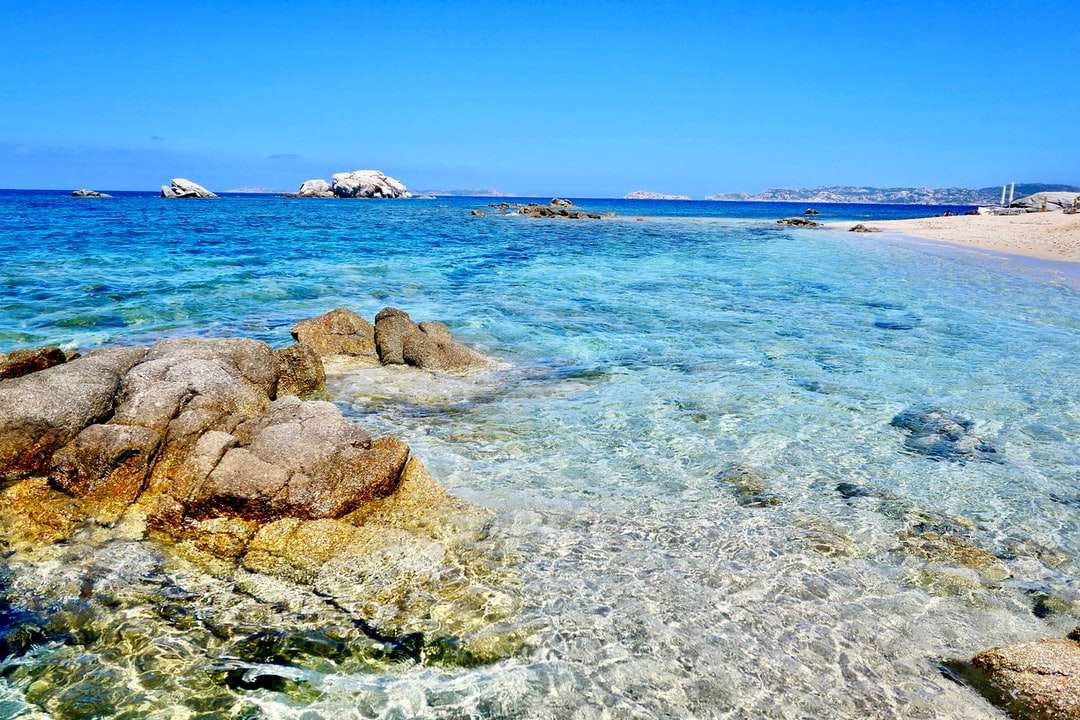 Brown skały na błękitnym morzu pod błękitnym niebem podczas dnia puzzle online