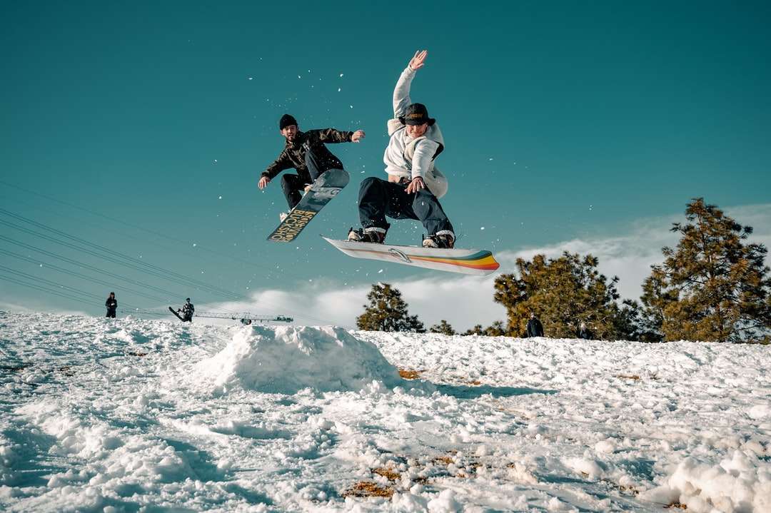 Mężczyzna w czarnej i białej kurtki jazda na snowboardzie puzzle online