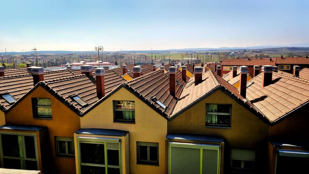 Brązowe i zielone betonowe domy pod błękitnym niebem puzzle online