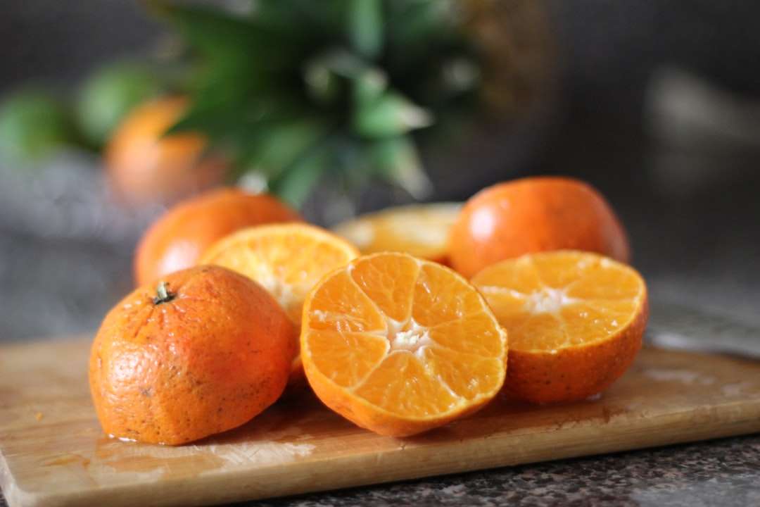 Pokrojone pomarańczowe owoce na brązowej drewnianej tacy puzzle online
