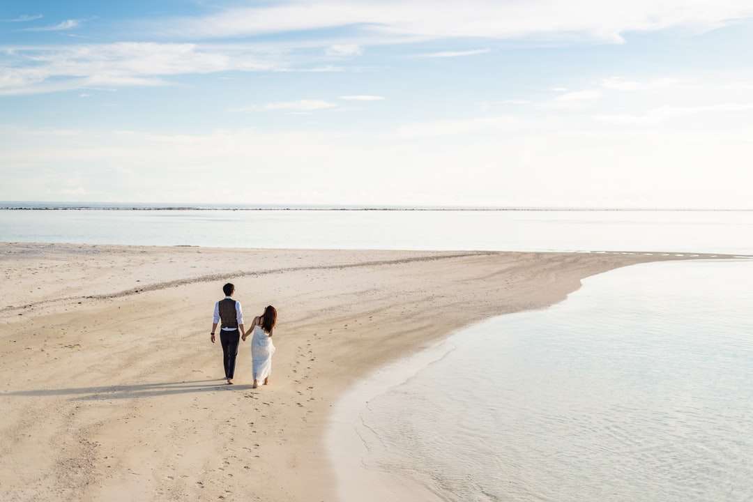 2 женщины и мужчина гуляют по пляжу днем головоломка