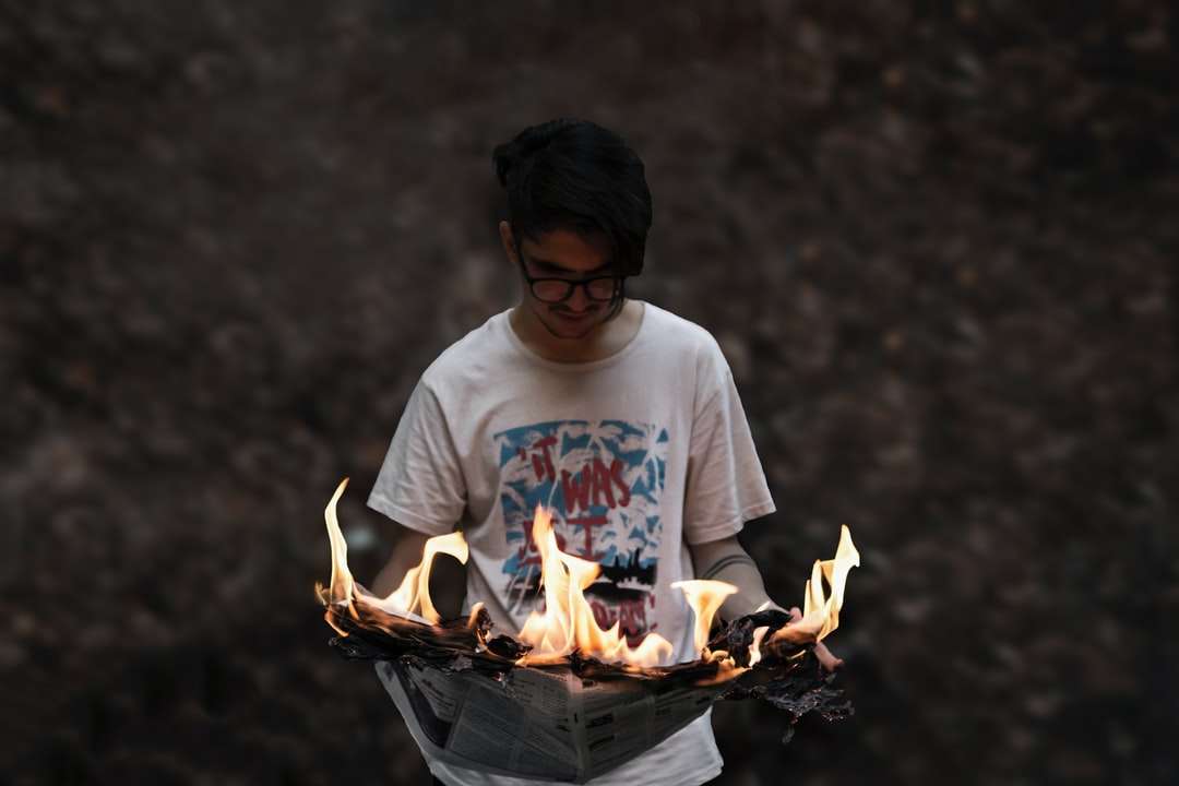 Mężczyzna w białej załogi szyi t-shirt trzyma ogień puzzle online