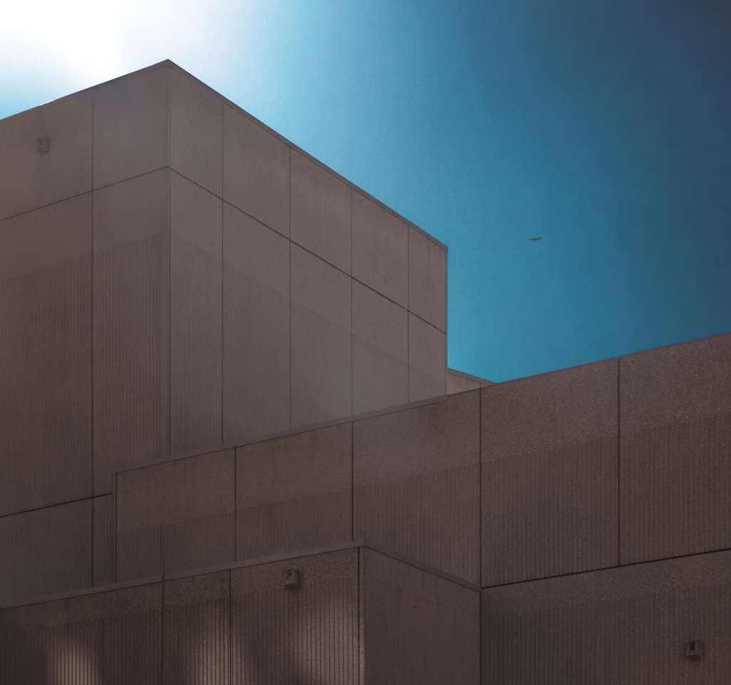 Szary betonowy budynek pod błękitnym niebem podczas dnia puzzle online