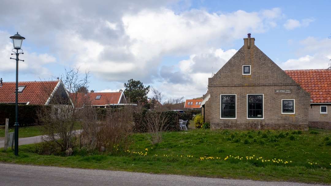 Brązowy i biały betonowy dom blisko zielonej trawy pola puzzle online