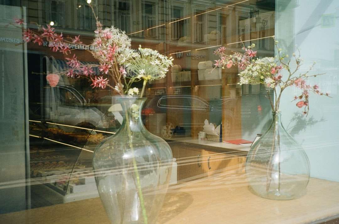 Białe i różowe kwiaty w jasnym szklanym wazie puzzle online