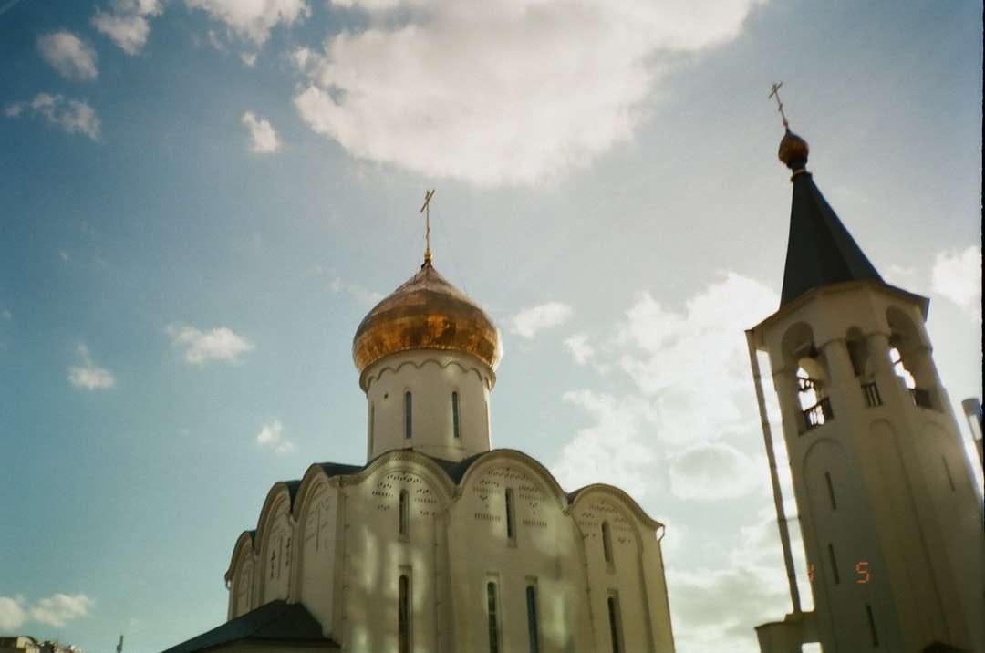 Biały i brązowy kościół betonowy pod błękitnym niebem puzzle online
