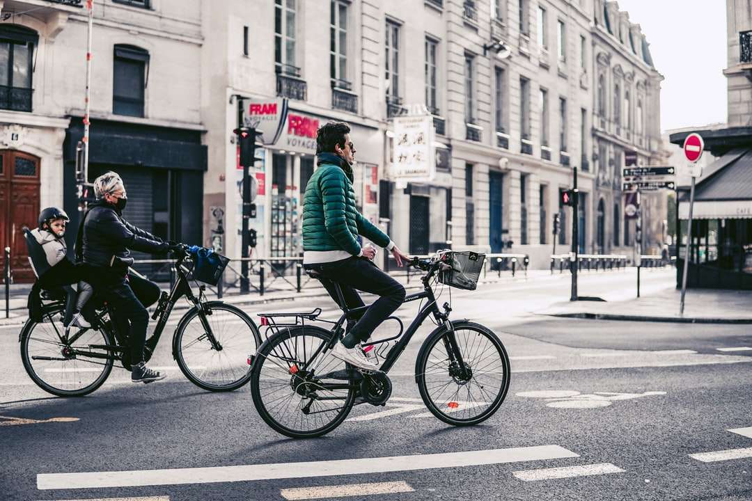 Mężczyzna w zielonej kurtce jazda na czarnym bicyklu na drodze puzzle online