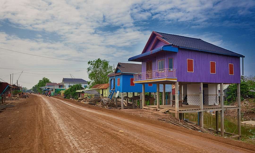 Niebieski i różowy drewniany dom w pobliżu drogi pod błękitne niebo puzzle online