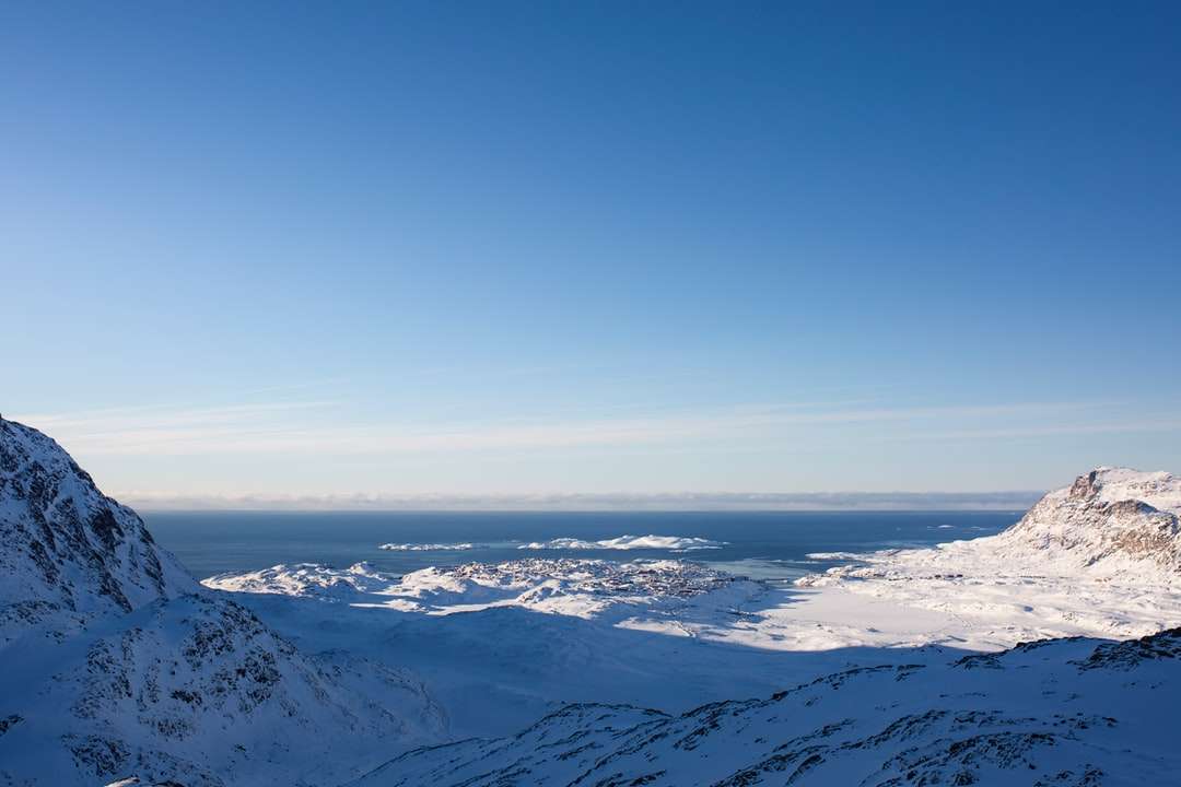 Śnieg pokryte górami pod błękitnym niebem w ciągu dnia puzzle online