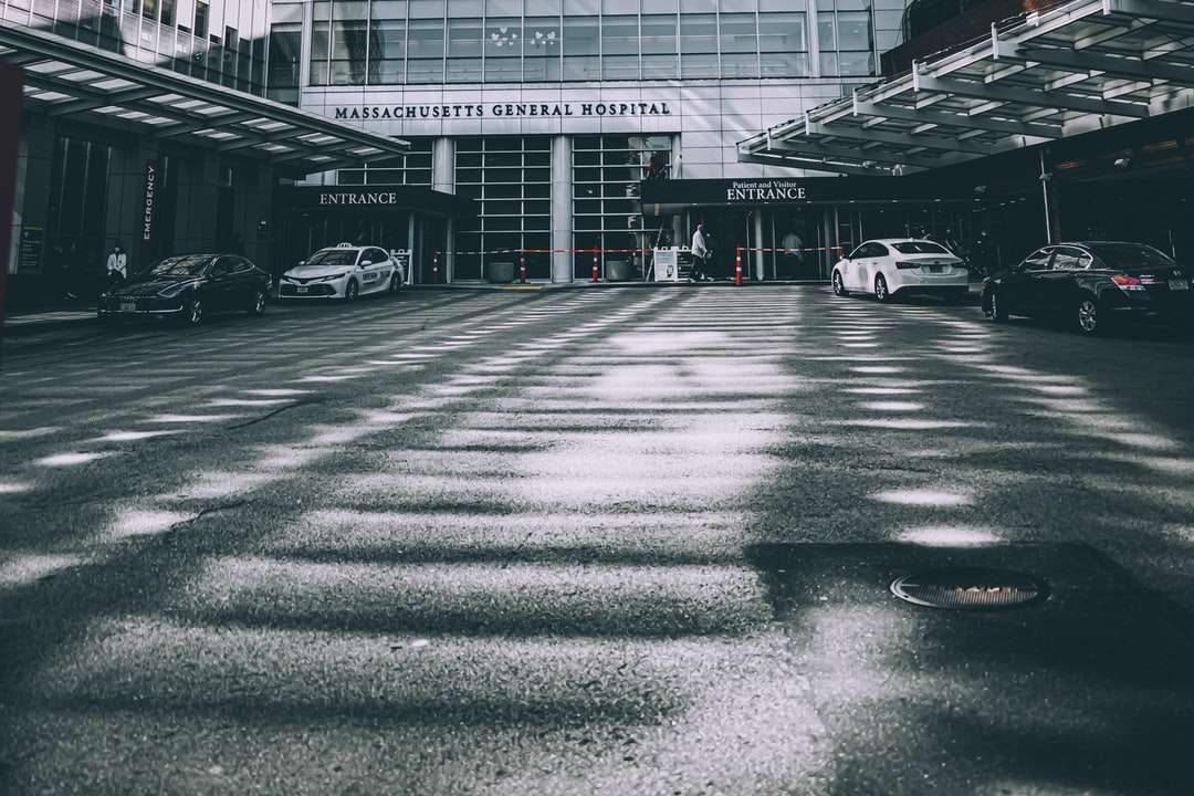 Grayscale zdjęcie samochodów zaparkowane przed budynkiem puzzle online
