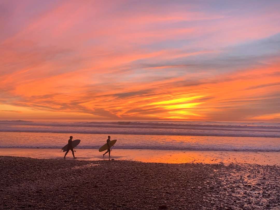 2 osoby chodzące na plaży podczas zachodu słońca puzzle online