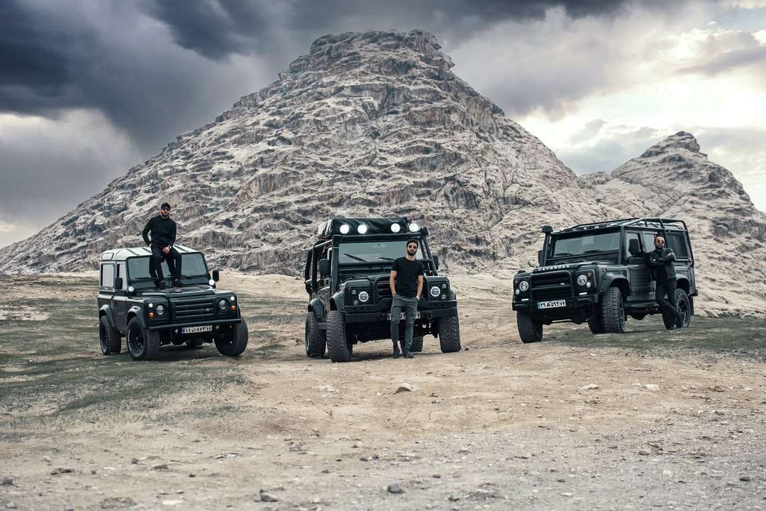 Czarny Jeep Wrangler na brązowym polu w pobliżu brązowej góry puzzle online