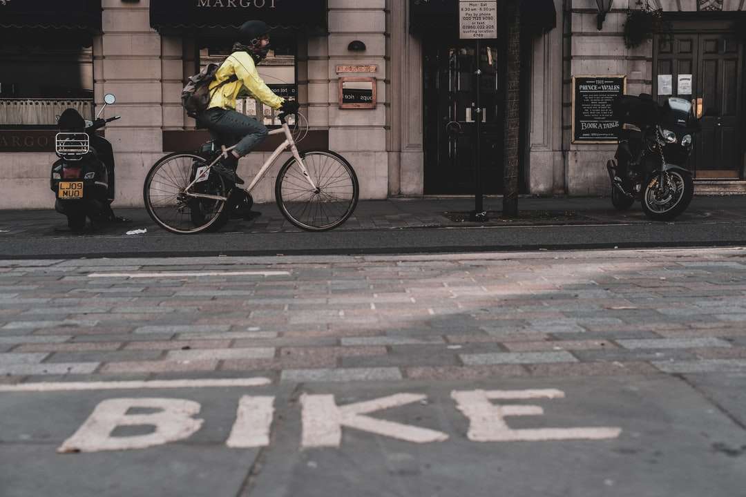 mężczyzna w żółtej koszuli jedzie na rowerze po chodniku puzzle online