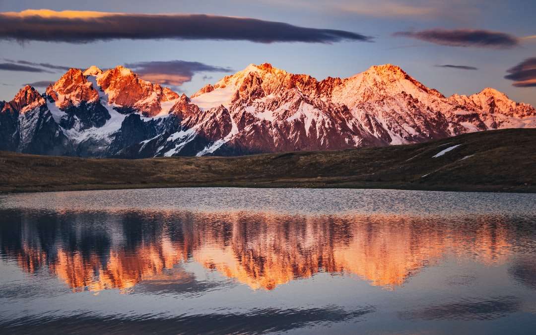 Brązowy i biały góra w pobliżu jeziora pod szarym niebem puzzle online