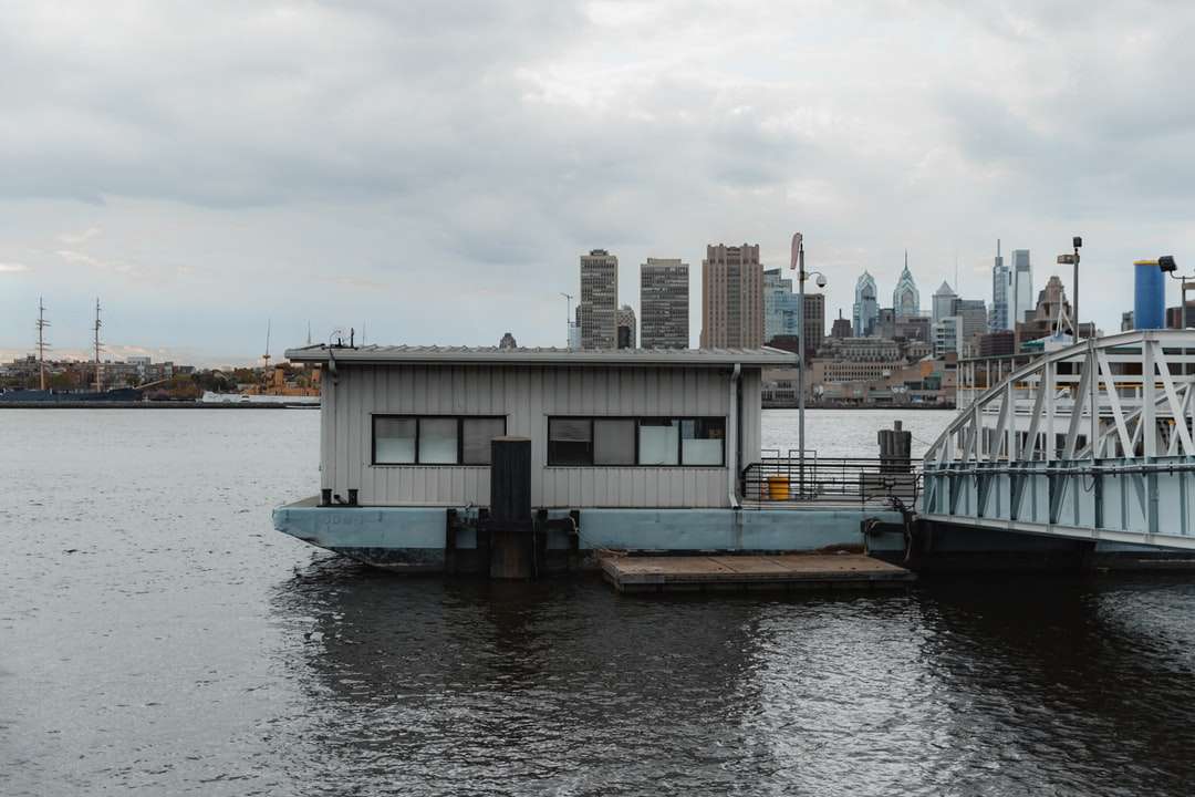 Biała i czarna łódź na wodzie w pobliżu budynków miasta puzzle online