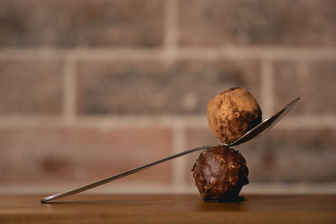 Trzy brązowe okrągłe owoce na brown drewnianym stole puzzle online