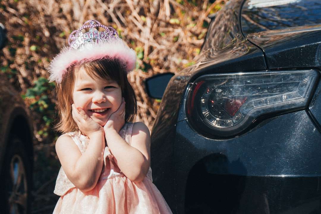 dziewczyna w różowej sukience siedząca na czarnym samochodzie puzzle online