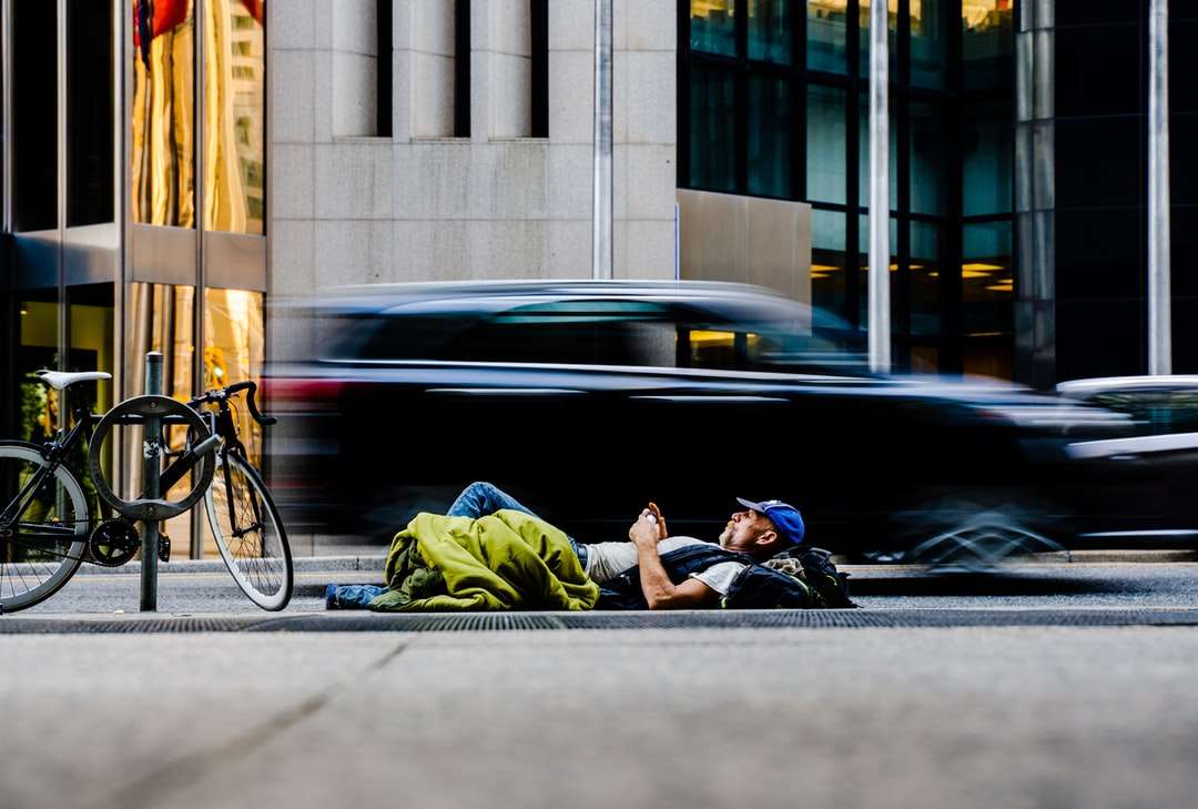 Mężczyzna w zielonej kurtce siedzi na czarnym rowerze drogowym puzzle online