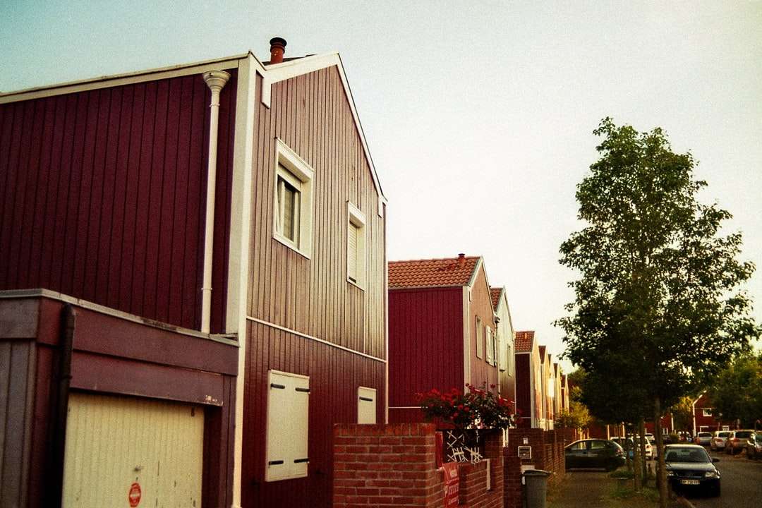 Czerwony i biały drewniany dom w pobliżu zielonych drzew w ciągu dnia puzzle online