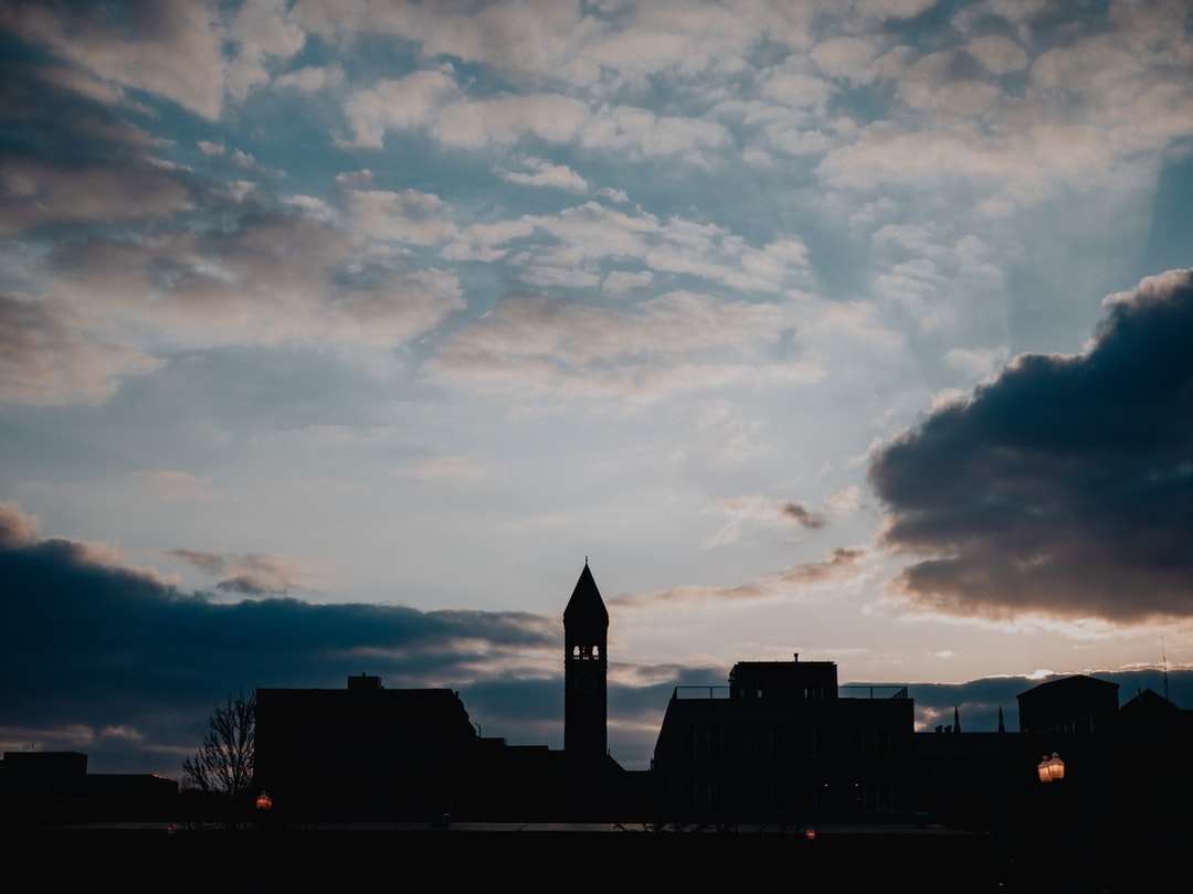 sylwetka budynku pod zachmurzonym niebem podczas zachodu słońca puzzle online